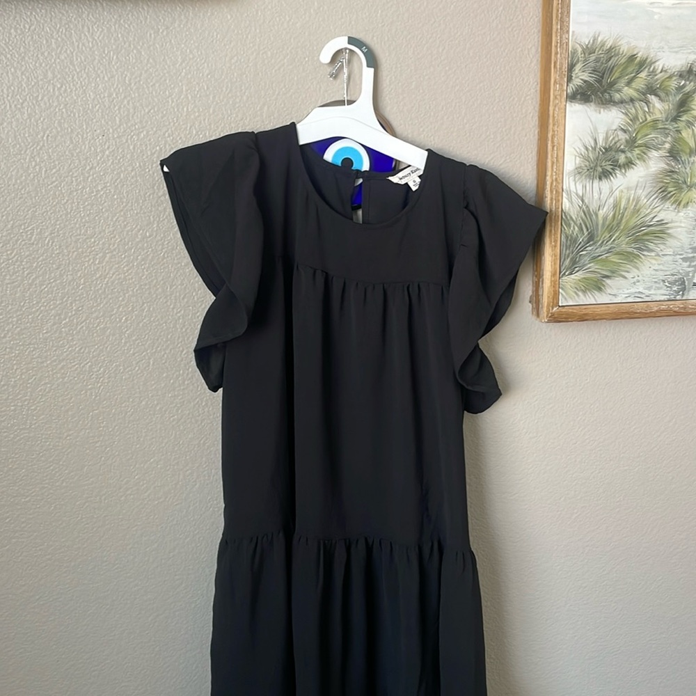 Never worn as it was too short for me. Very cute black ruffled dress